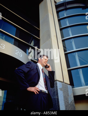 Executive man outside city office building.  Talking cellphone. Stock Photo