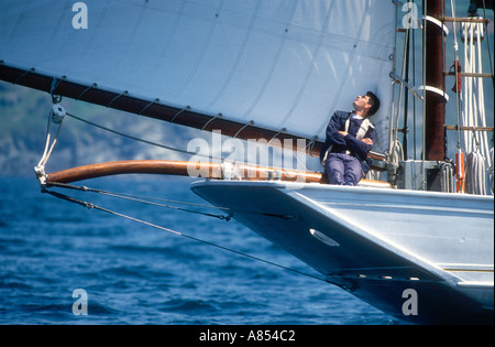 A crew member at the stern of the French navy owned gaff yawl Mutin a former tuna fishing boat  Stock Photo