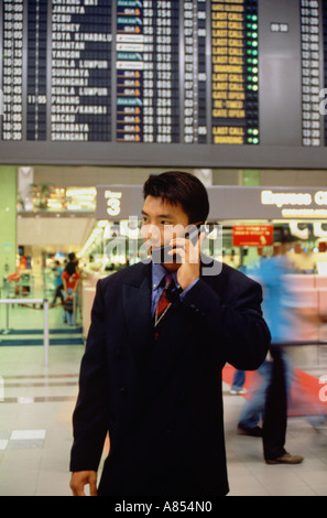 Young Asian business man in airport terminal building. Singapore. Stock Photo