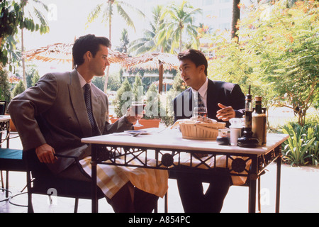 Two men sitting at table in outdoor cafe. Stock Photo