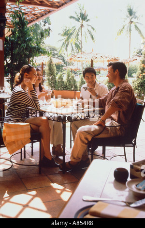 Four friends sitting on outdoor terrace of café restaurant. Singapore Stock Photo