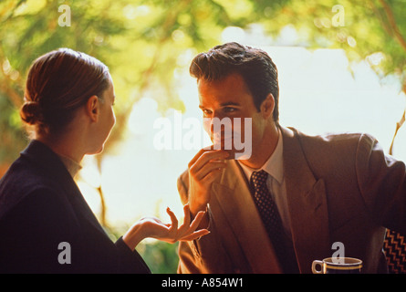 Young couple wearing business suits meeting in outdoor restaurant. Stock Photo