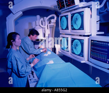 Surgeon and nurse with patient in hospital Angiography scanning room. Stock Photo
