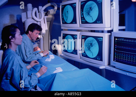 Surgeon and nurse with patient in hospital Angiography scanning room. Stock Photo