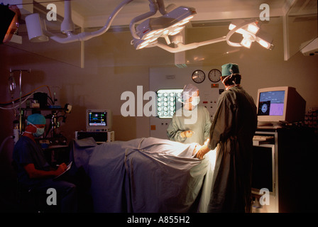 Neuro surgery. Surgeon, nurse and anesthetist with patient in hospital operating theatre. Stock Photo