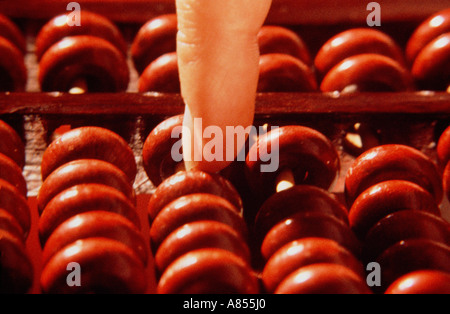Close-up of man's finger on counters of an abacus. Stock Photo