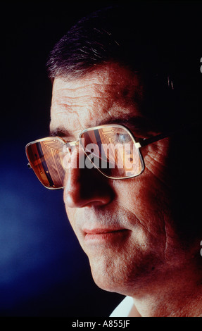 Indoor portrait of middle age man wearing spectacles with reflected image of computer circuit. Stock Photo