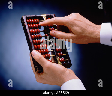 Studio close-up of man's hands using an abacus. Stock Photo