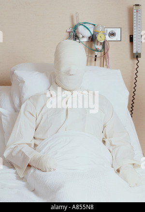 Male patient with serious burns bandaging lying in hospital bed. Stock Photo