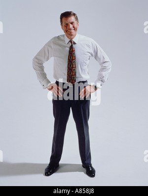 Middle aged man with hands on his hips standing in studio. Stock Photo