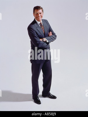 Middle aged man with arms folded standing in studio. Stock Photo