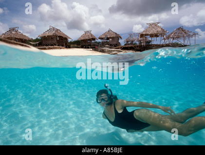 Under over view of woman snorkeling in shallow water Northwest Point Providenciales Provo Turks Caicos Islands Stock Photo