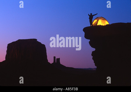 a camper stretches before turning in for the night at his campsite overlooking Monument Valley on the Arizona - Utah border Stock Photo