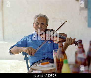 Old man playing the violin in a taverna, country village near Lindos, Rhodes, Dodecanese Islands, Greece Stock Photo