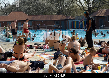 People enjoying sunny afternoon London Fields LIDO London Borough of Hackney outdoor swimming pool Stock Photo