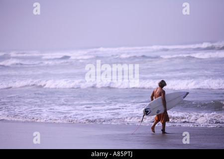 Surfer at the beach Stock Photo