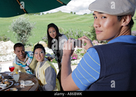 Man taking a picture of three people Stock Photo