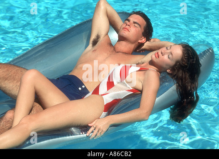 romantic couple relaxing on raft in swimming pool Stock Photo