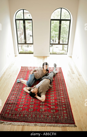 Young couple resting on carpet, high angle view Stock Photo