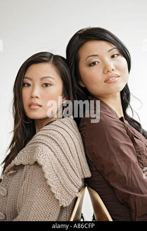 Two young women back to back, portrait Stock Photo