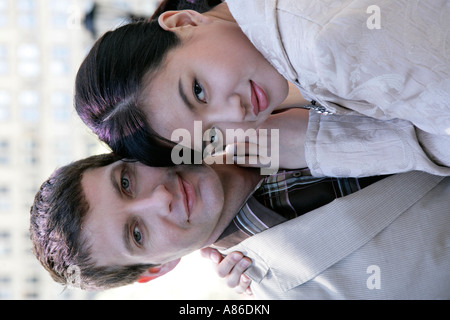 Interracial  couple embracing looking at camera Stock Photo