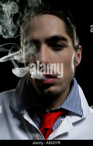 Close-up of young man with smoke coming out of his mouth Stock Photo