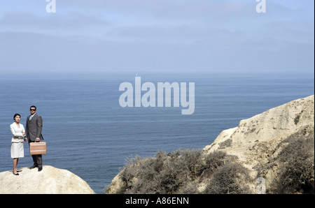 View of a man and a woman standing on a cliff. Stock Photo