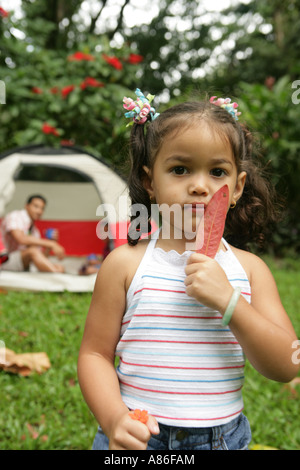 Portrait of girl holding leaf and flower Stock Photo