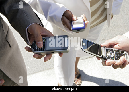 Three people are holding their cellphones. Stock Photo