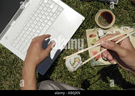 An executive is working on his laptop during lunch. Stock Photo