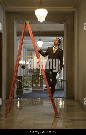 View of a businessman standing on a ladder. Stock Photo