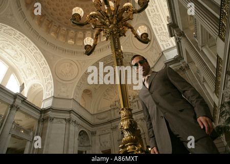 View of a businessman standing beside an ornate lamp. Stock Photo
