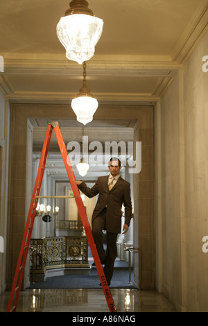 View of a businessman standing on a ladder. Stock Photo