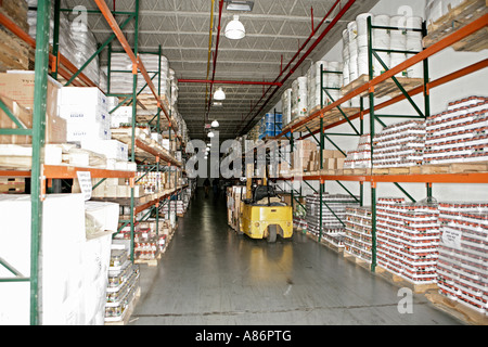 View of a forklift inside a well stocked warehouse. Stock Photo