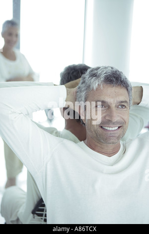 Mature man smiling leaning against a mirror Stock Photo