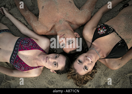 View of three people lying on a beach. Stock Photo