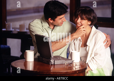 Couple playfully working together. Stock Photo