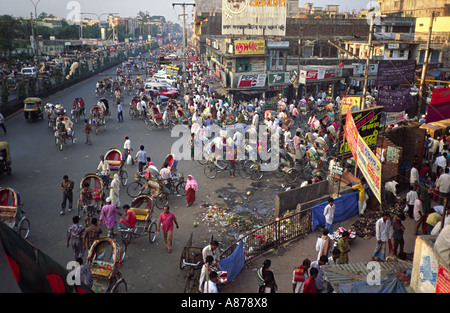 Rickshaws, cars and people on the busy streets of Dhaka early in the evening. Bangladesh Stock Photo