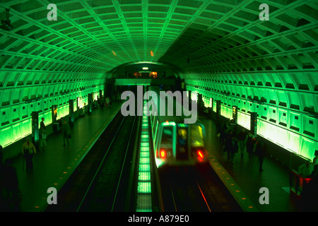 Metrorail train pulling into an underground subway station as commuters stand on the platform Washington DC Stock Photo