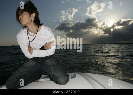 View of man kneeling on a yacht. Stock Photo