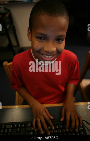 Boy (5-7) smiling with hands on keyboard, portrait Stock Photo