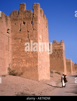 Local man,walking, passing part of the red wall running around Taroudannt,Morocco Stock Photo