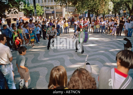 Native Chilean street performers entertain spectators with dancing and bass drums in Parque Italia Valparaíso Chile Stock Photo
