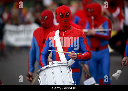 Clowns and a marching band of Spidermen march thorugh the town of Bognor Regis in the UK Stock Photo