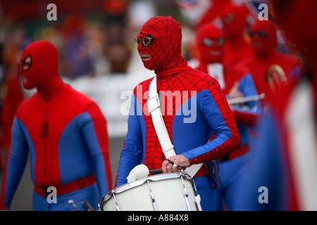 Clowns and a marching band of Spidermen march thorugh the town of Bognor Regis in the UK Stock Photo