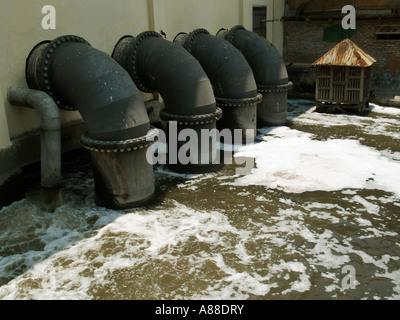 Polluted waste water pours from factory pipes and drains into local river in slum area of Surabaya,Java,Indonesia Stock Photo