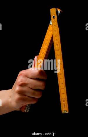Female hand holds Folding carpenter rule. Stock Photo