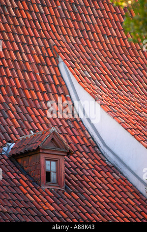 Red clay tiled rooftops and a small dormer window in the historic center of Poznan Wielkopolskie, Poland. Stock Photo