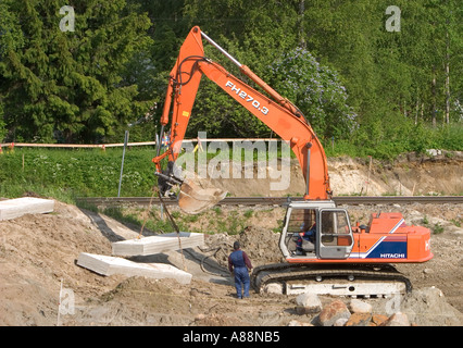 Digger lifting a concrete slab at construction site , Finland Stock Photo
