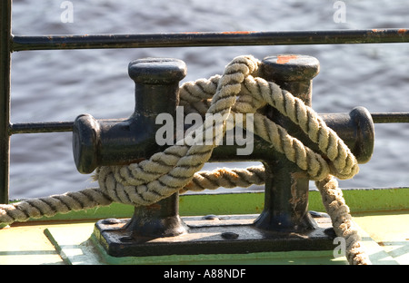 Mooring post with thick manila rope tied to it Stock Photo